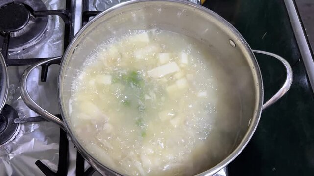 Traditional Colombian mote de queso soup boiling on a gas stove