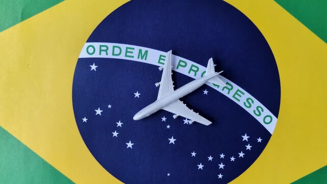 An airplane on the brazil flag as a conceptual backdrop for flights and travel. An airplane on the brazil flag as a background for your design