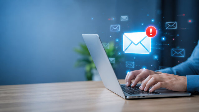 Professional typing on laptop with virtual email notification icon, digital communication, technology, and online messaging in modern office workspace