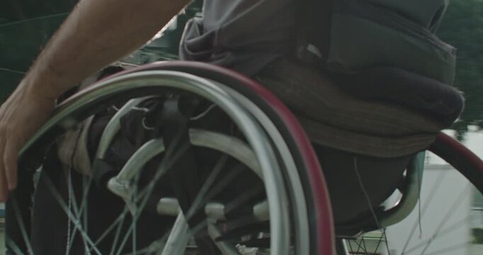 Close-up of a wheelchair basketball player propelling a sports wheelchair across the court during practice, emphasizing adaptive mobility, speed, 