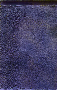 Purple pebbledash wall texture with weathered mossy coping