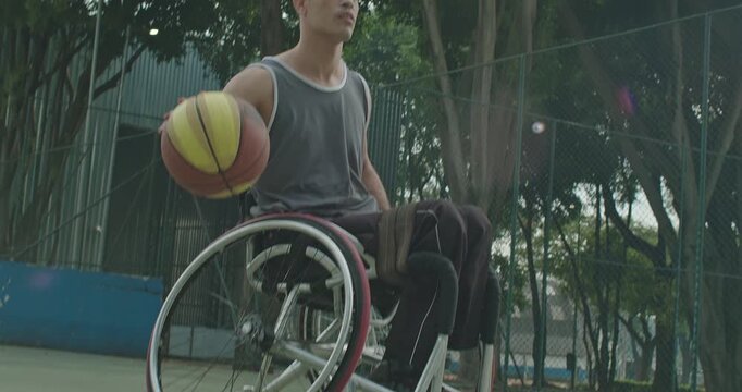 Close-up of a wheelchair basketball athlete dribbling during outdoor practice, showcasing adaptive athletics, concentration, physical fitness, resilience, disability inclusion,