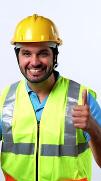 Portrait of a Joyful and Confident Indian Bearded Civil Engineer in Fluorescent Safety Jacket and Yellow Hard Hat Celebrating Success standing against White background