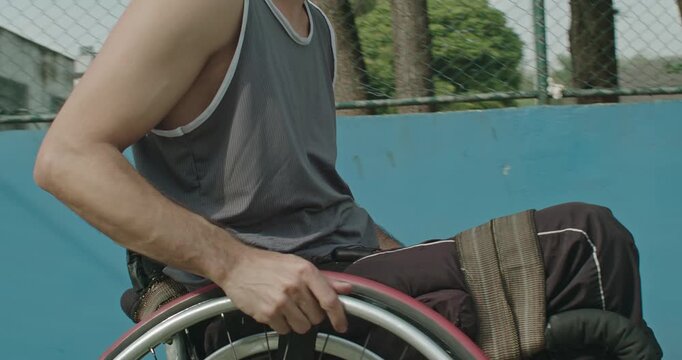 Athlete using a sports wheelchair pausing after training on an outdoor basketball court, representing resilience, recovery, adaptive athletics, disability inclusion, 