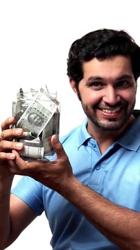 Handsome bearded Indian man holding a glass jar filled with ₹500 notes, radiating positivity and confidence, standing isolated on a white background, saving concept