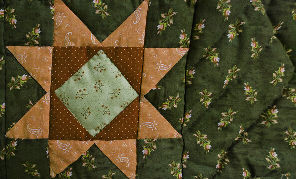 Patchwork stars in autumn tones, warm and cozy mood, handmade quilt craft against a neutral background with copy space
