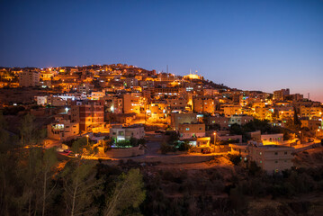 Obraz premium Night view of the illuminated city of Al-Karak on the hills, Jordan