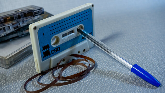 Cinta de cassette retro con la cinta fuera y un bol&iacute;grafo para rebobinar