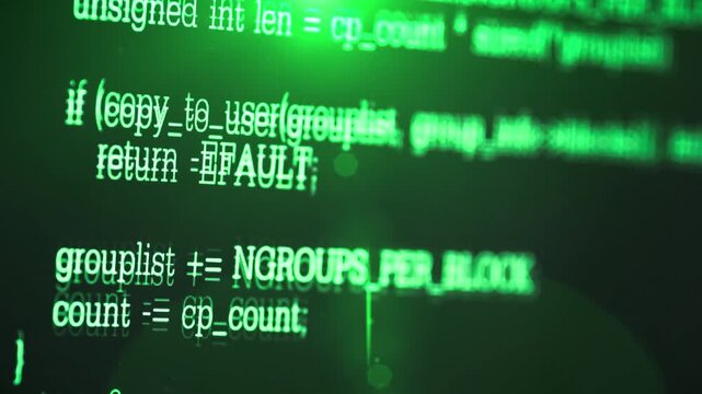close up shot of computer monitor display showing green programming source code lines on dark screen.