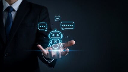 Fototapeta premium AI Assistant in Hand: A businessman in a suit holds a glowing chatbot icon in his palm, symbolizing artificial intelligence and modern digital assistance.