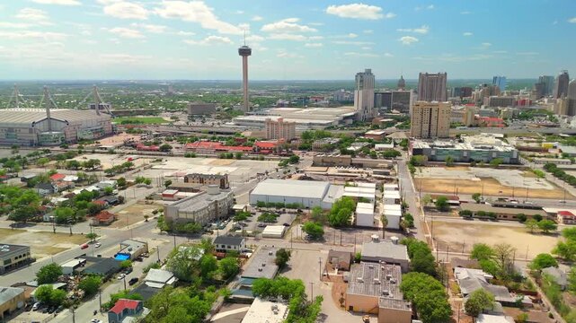A brief aerial approach centers on the iconic tower above a sprawling low rise cityscape.