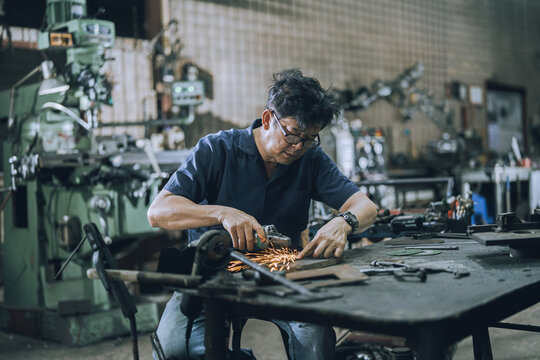 Skilled Machinist Using Angle Grinder in Small Local Machine Shop for Metalworking and Industrial Repair