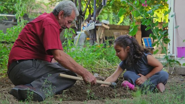 An elderly man and young girl sit under a tree in a rural backyard, tending soil and caring for plants, showing family bonding, gardening, outdoor learning, sustainability, and village life.