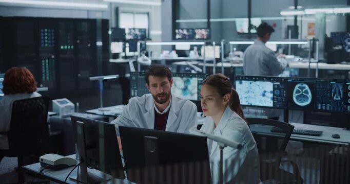 Caucasian Male and Female Medical Scientists Talk While Examining Brain Scan Data on Computer Monitors in Medicine Research Laboratory, Using Ai Technology for Neurology Treatment and Drug Development