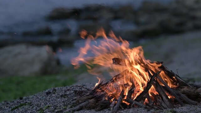 Beach bonfire with sound of ocean waves and cargo ship on the horizon at dusk