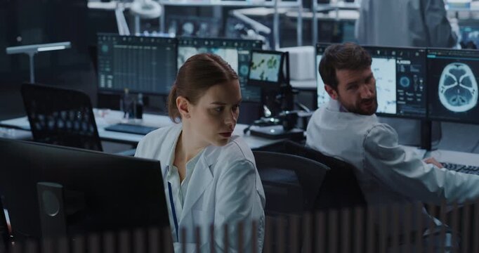 Portrait of Female Scientist Types on a Computer While a Male Colleague Examines Brain Scan Imagery on Monitors in a High-tech Medical Research Lab, Applying Ai for Pharmaceutical Innovation.
