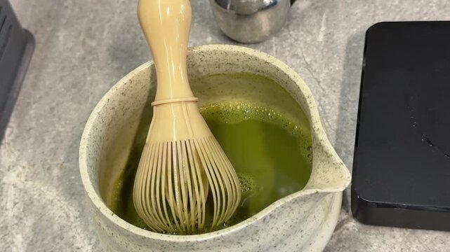 poor quality matcha is swamp green Iced matcha latte preparation in clear plastic cup showing pale green color uneven texture and diluted tea drink served with ice and black straw