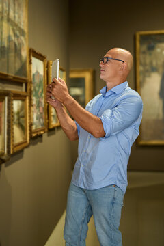 Man in the museum looks at art exhibitions gallery