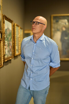 Man in the museum looks at art exhibitions gallery