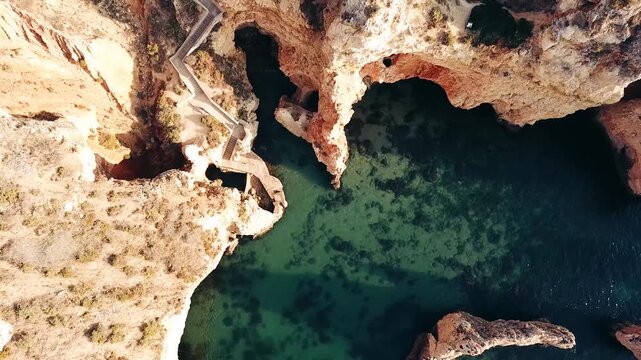 Aerial view of the dramatic limestone cliffs and turquoise water at Algar Seco in Portugal