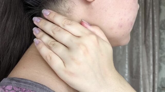 Woman checking lymph nodes on neck, self-examination, healthcare, medical awareness and preventive health concept.