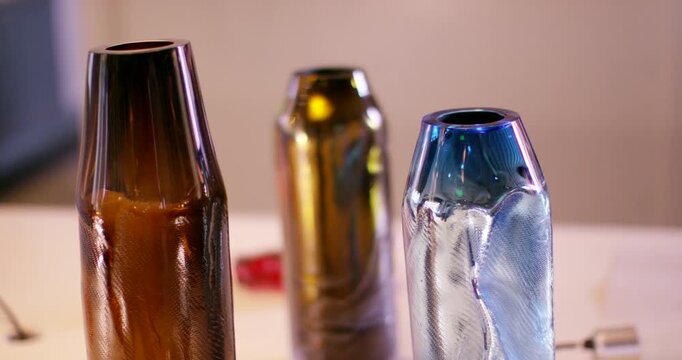 A collection of small clear glass vases with yellow flowers on a white surface