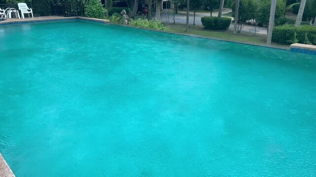 Private blue deep pool during the rain. Water drops