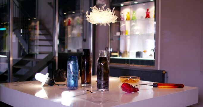 Artistic white glass light fixture hanging in a bright studio workshop