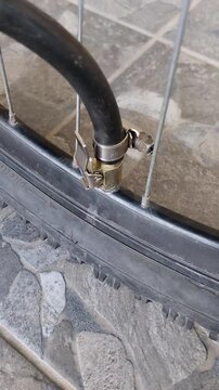 The process of inflating a bicycle wheel with an air pump close-up, Bicycle Wheel Maintenance Pumping Up Flat Tyre with Hose 