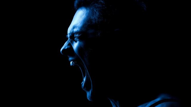 Man shouting in extreme emotional distress. Portrait of man suffering from mental breakdown and inner pain. Psychological concept of hysteria and life burnout.