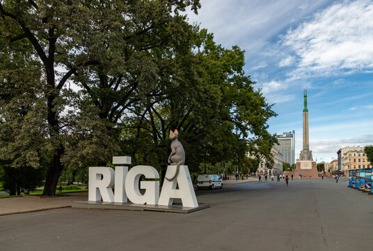 Riga, Latvia - August 26, 2025: A picture of the cat from the movie Flow on top of the Riga sign., with the Freedom Monument on the far right.