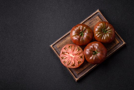 Fresh pink and black tomatoes adora or kumato as an ingredient for a salad. Tomatoes adora or kumato