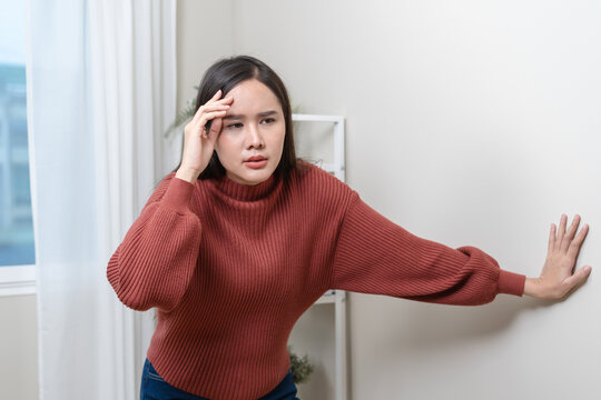 A woman is feeling dizzy and losing balance while standing.