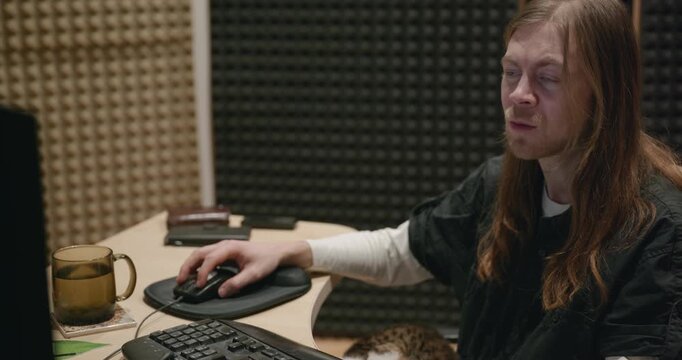 Caucasian man drink hot water in home sound recording studio while working. Single male is drinking tea in evening. 4K 10-bit