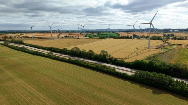 Aerial view of wind turbines in golden wheat field for sustainable energy in UK