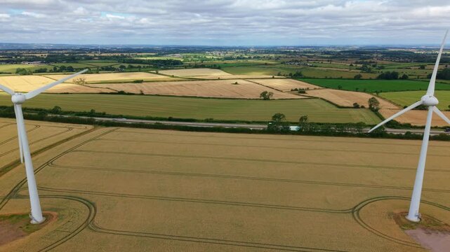 Aerial view of wind turbines in golden wheat field for sustainable energy in UK