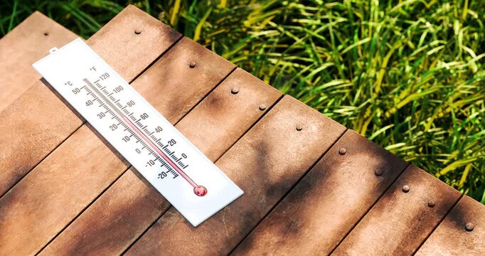 3D animation of dual scale thermometer lying flat on outdoor garden wooden table with rising temperature during sunny daytime