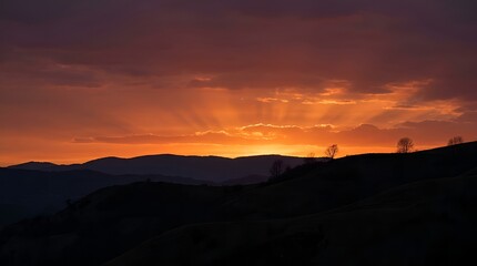 Fototapeta premium Dramatic sunset over silhouette mountain range in the countryside.