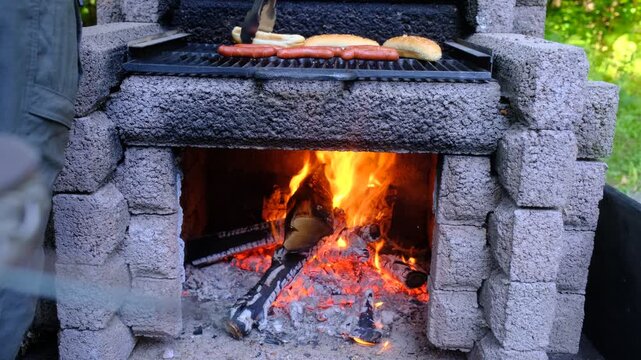 Cuisson de hot-dogs sur un feu de camp pendant les vacances. Saucisses et pains &agrave; hot-dog &agrave; faire cuire.