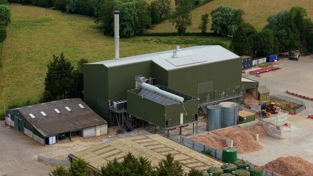 Close up aerial view of giant air-cooled condenser units and rooftop HVAC cooling fans at a modern biomass renewable energy plant.