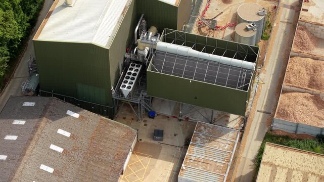 Close up aerial view of giant air-cooled condenser units and rooftop HVAC cooling fans at a modern biomass renewable energy plant.