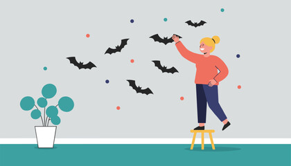 Naklejka premium Young woman stands on a wooden stool to put up flying bat stickers on her room wall as part of Halloween decor.
