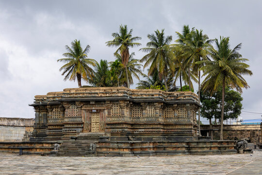 Ancient Chennakesava Temple in Belur, Karnataka, showcasing exquisite Hoysala stone architecture beneath towering coconut palms. Ideal for travel, heritage, culture, architecture, and tourism projects