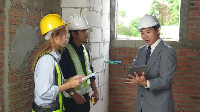 Businessman and construction engineers reviewing project plans at a building site, discussing construction management, teamwork and site inspection.