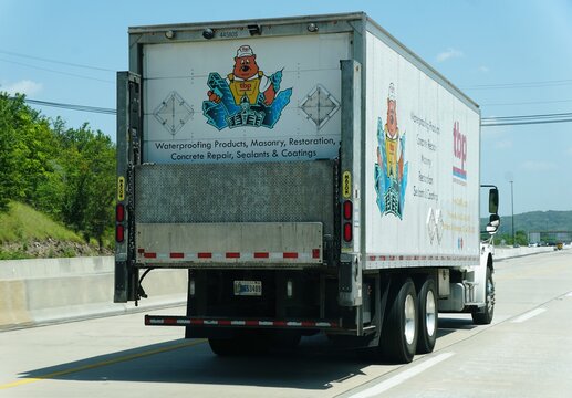 Pennsylvania, U.S.A - Jul 2, 2026 - White TBP box truck displaying cartoon beaver and construction product list traveling on the highway.