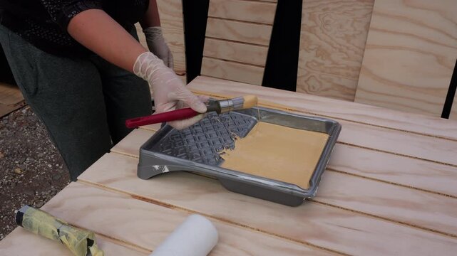 Person painting wooden slats yellow