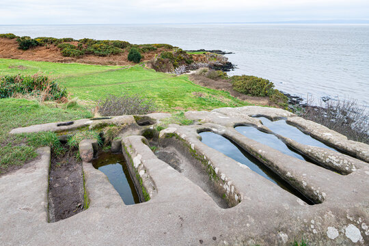 Pre Norman conquest graves cut in solid rock next to the ruins of St Patricks Chapel dating back to Anglo Saxon times perched above the sea at Heysham, Lancashire, England UK