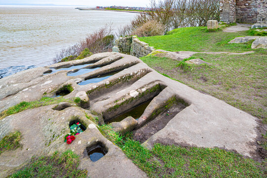 Pre Norman conquest graves cut in solid rock next to the ruins of St Patricks Chapel dating back to Anglo Saxon times perched above the sea at Heysham, Lancashire, England UK