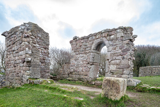 The ruins of St Patricks Chapel dating back to Anglo Saxon times perched above the sea on a bleak day in February at Heysham, Lancashire, England UK