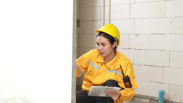 Female construction inspector reviewing a checklist at an indoor building site, ensuring safety, quality control and construction compliance.